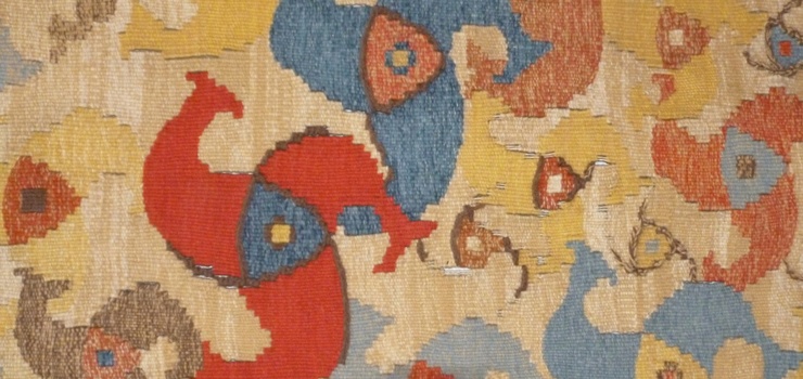 Auf dem Bild sieht man einen Teppich mit bunten boomerangähnlichen Mustern. Das Bild gehört zum Beitrag Greifswalder Künstlerinnen