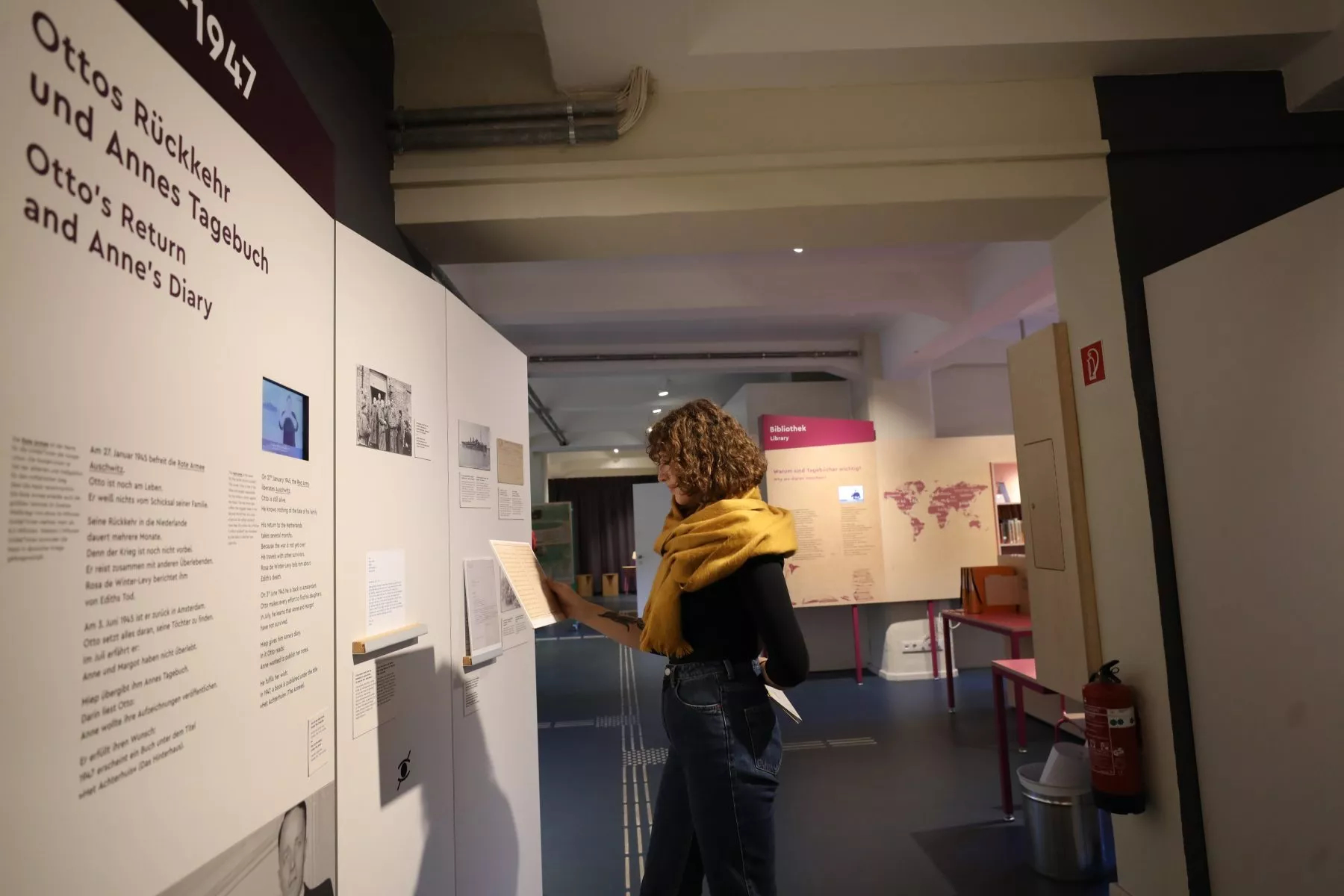 Das Bild zeigt einen Ausschnitt aus einer Ausstellung in der eine Person sich gerade etwas ansieht. Das Bild gehört zum Beitrag Umgang mit und die Rezeption von Antisemitismus an Gedenkstätten und Erinnerungsorten