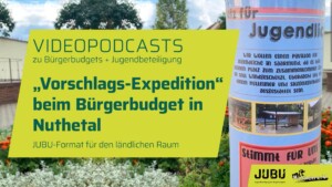 Auf dem Bild ist ein begrünter Hof zu sehen mit einer Säule, um die ein Plakat gewickelt ist. Im vordergrund steht Vorschlags-Expedition beim Bürgerbudget in nuthetal