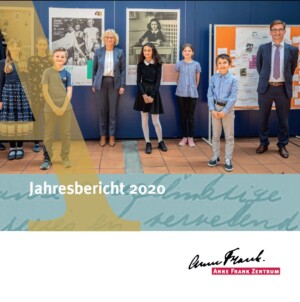 Auf dem Bild sieht man ein Gruppenfoto auf denen die Menschen mit einer Armlänge voneinander wegstehen. Sie sind vor Plakaten aufgestellt. In der Mehrheit sind es Kinder, in der Mitte steht Ministerin Lambrecht und ganz rechts der Geschäftsführer des Anne Frank Zentrums. Unter dem Bild steht Jahresbericht 2020